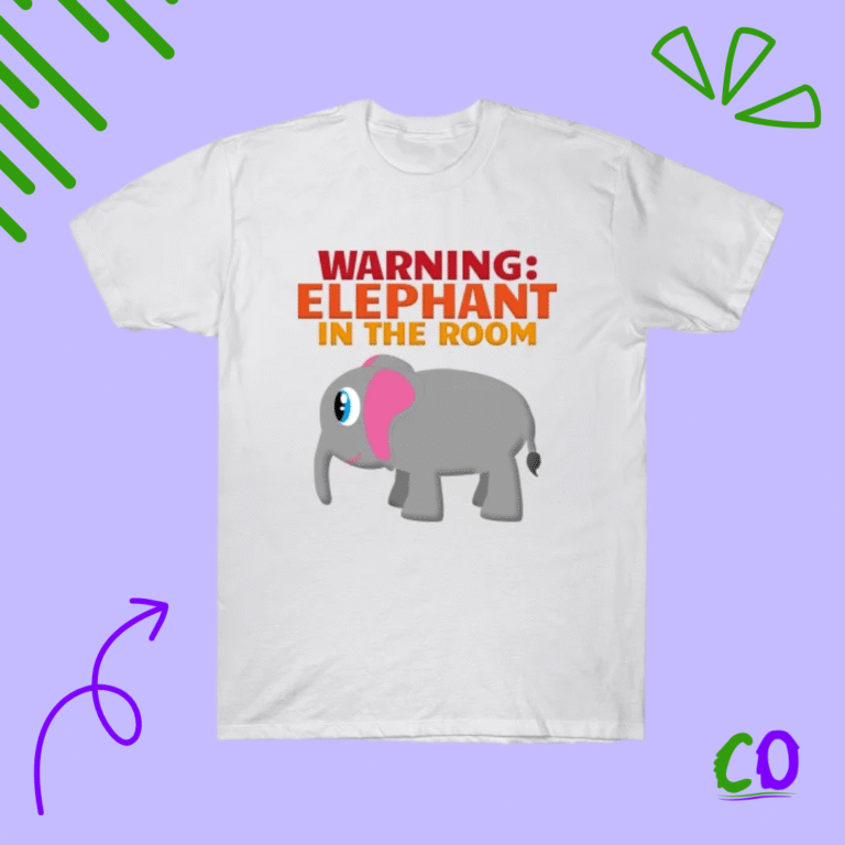 White t-shirt with cute grey elephant illustration and bold red “Warning: Elephant in the Room” text, humorous animal graphic tee from Creation Overload.